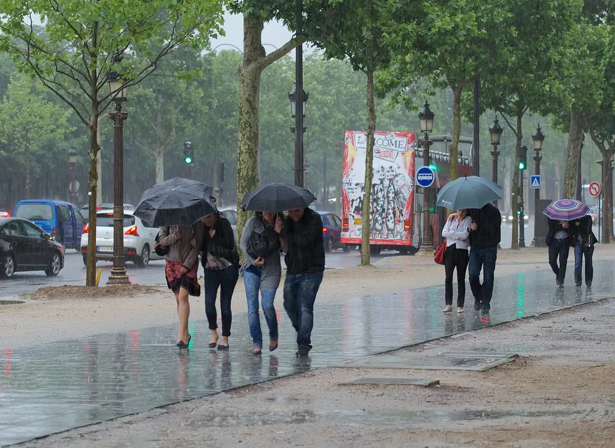 Les Champs-Élysées sous une averse de juin, la pluie parisienne typique
