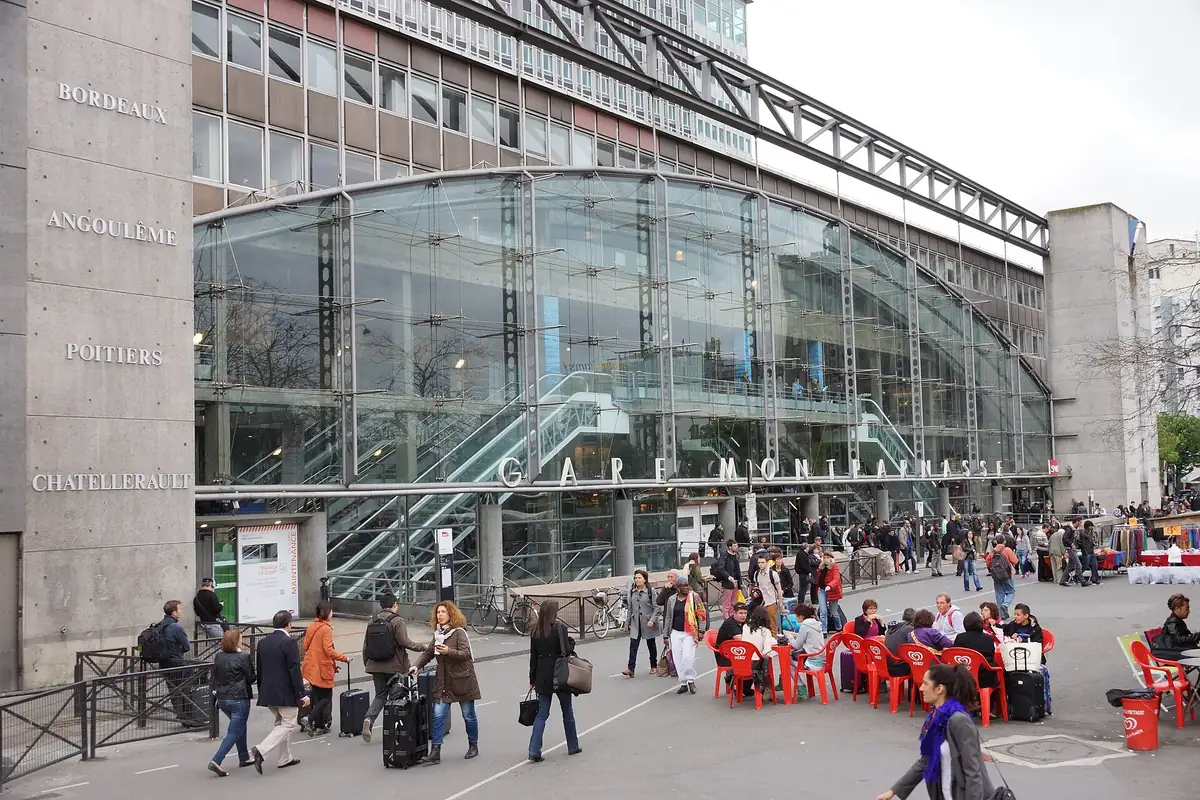 La façade vitrée de la gare Montparnasse, les noms de destinations gravés sur les piliers