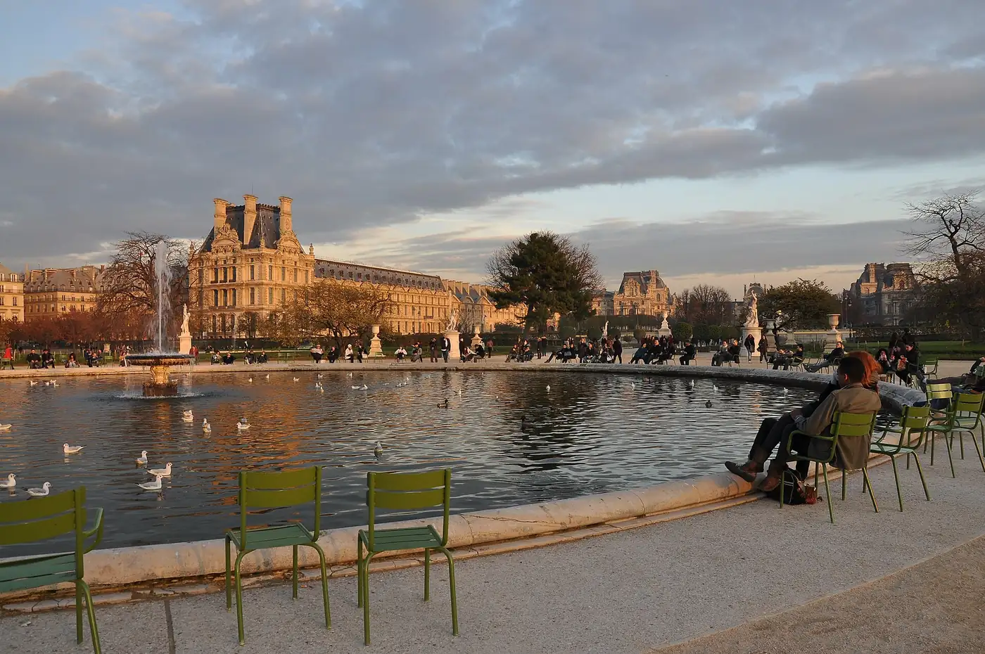 Le grand bassin rond des Tuileries, ses chaises vertes et le pavillon de Flore du Louvre en fond